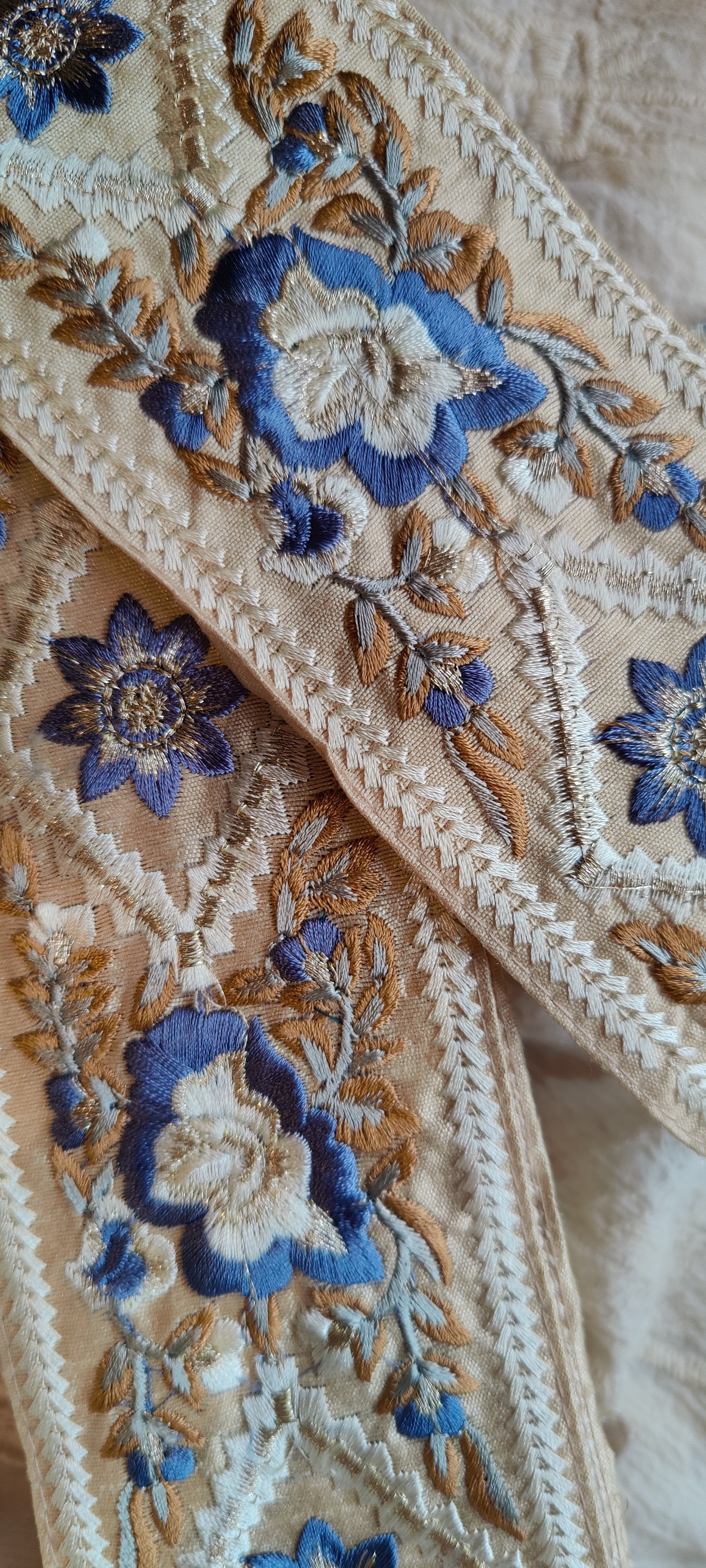 Close-up of decorative fabric with floral patterns in blue and gold.