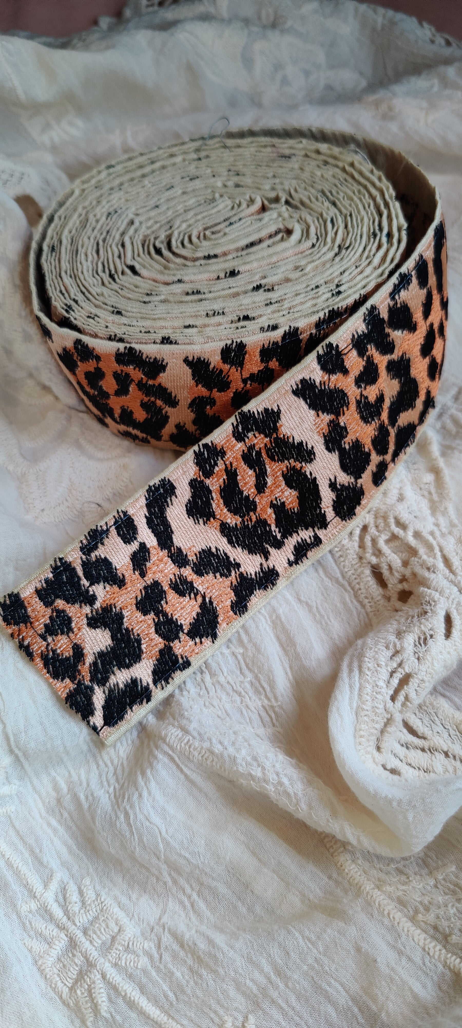 Roll of leopard print ribbon on a textured surface